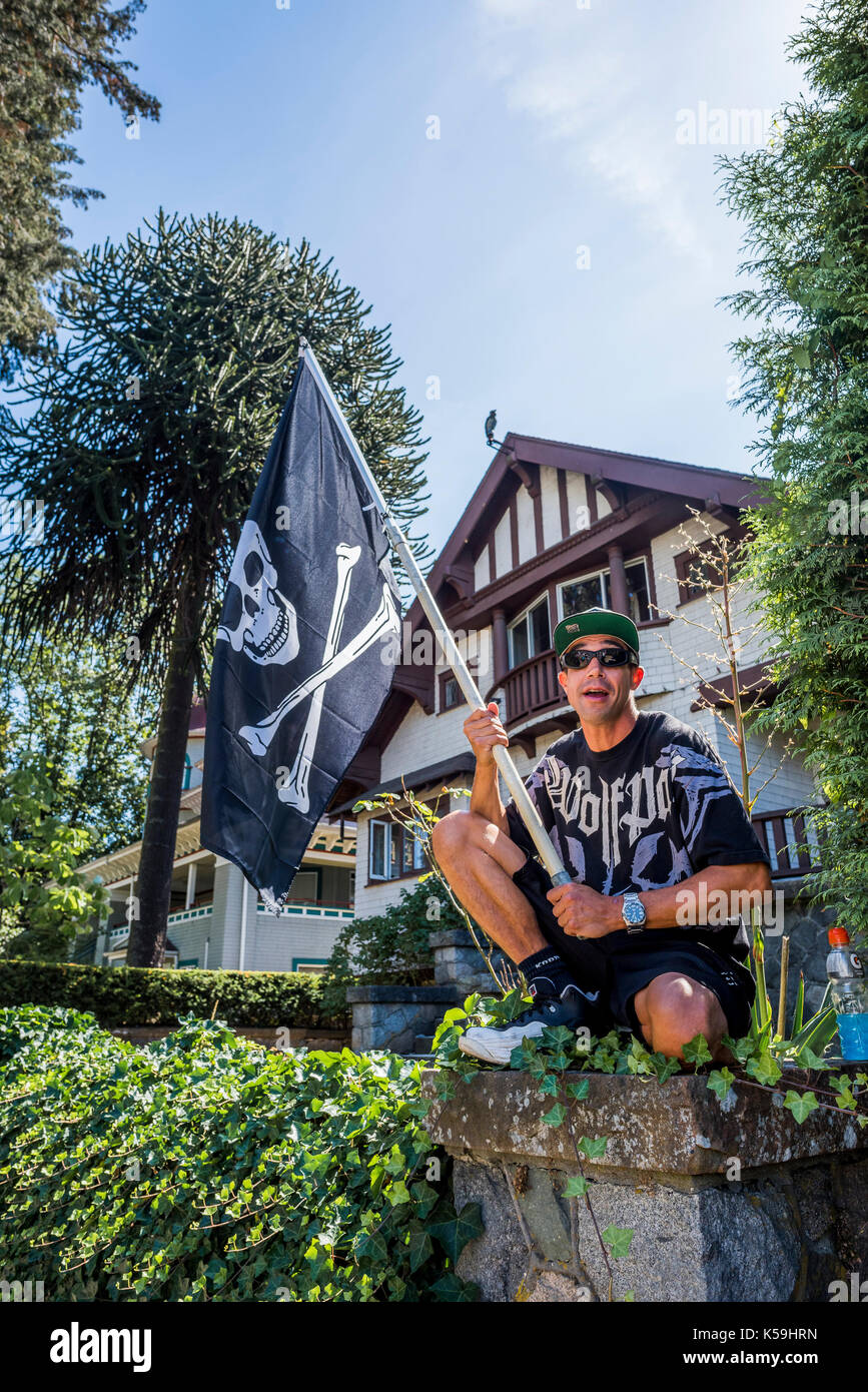 Man with Jolly Roger pirate flag at Anti-Racism Rally, City Hall, Vancouver, British Columbia, Canada. Stock Photo
