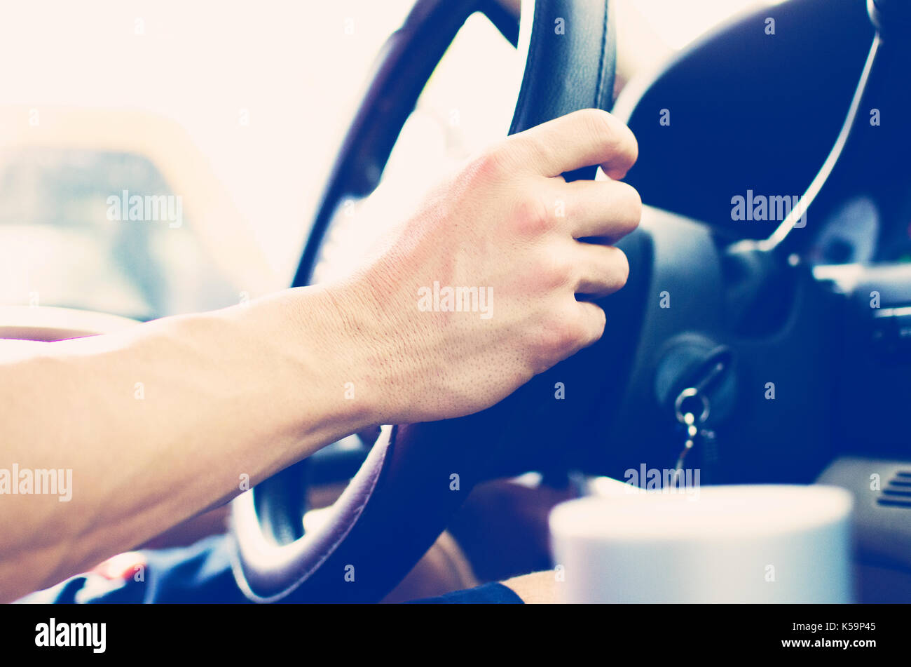 Driver grips steering wheel in vehicle during drive in traffic
