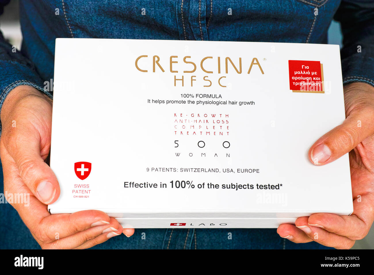 Paphos, Cyprus - November 13, 2015 Woman hands with Crescina HFSC Re-Growth Anti-Hair Loss Complete Treatment box. Crescina HFSC preserves cell longev Stock Photo