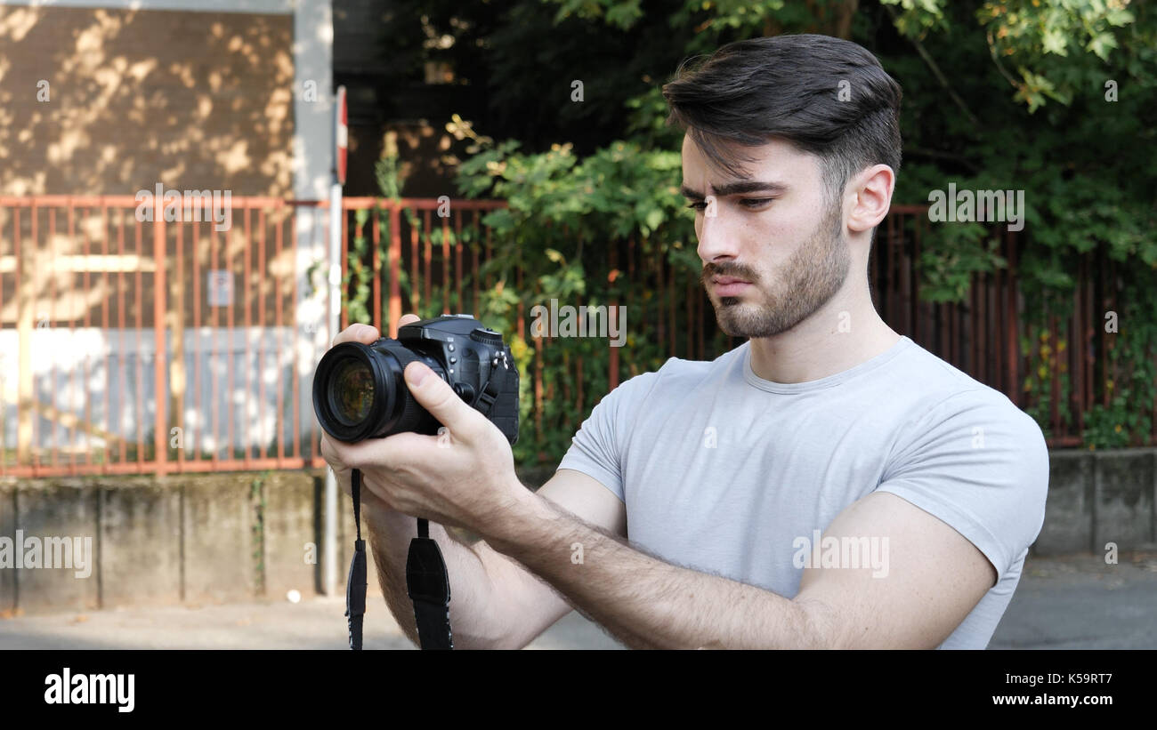 Young man posing with photo camera Stock Photo