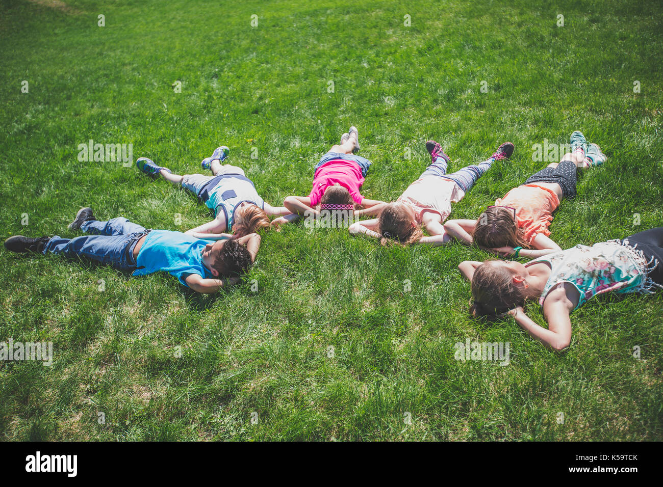 group of friends laying in the grass Stock Photo