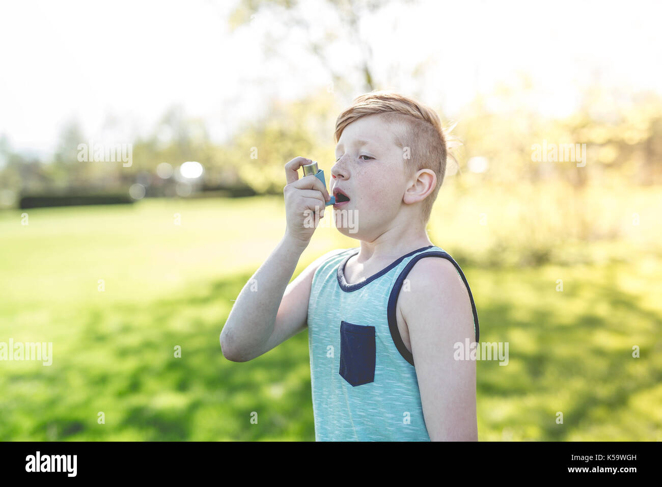 Boy using an asthma inhaler in the park Stock Photo - Alamy