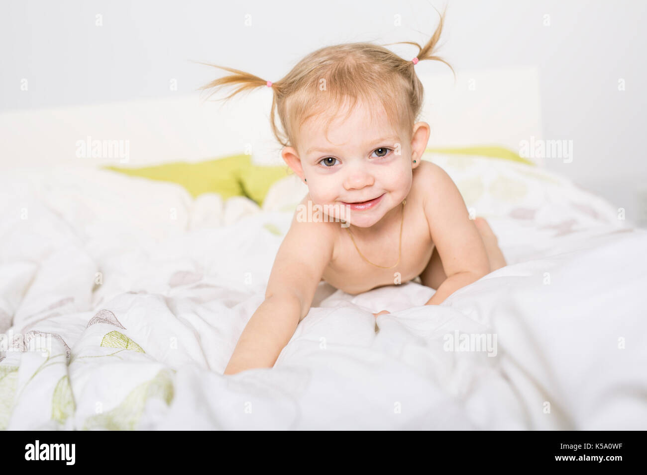 two year old blond girl in bed at home Stock Photo Alamy