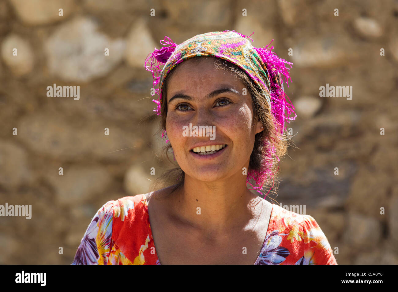 Close up portrait of smiling Pamiri / Badakhshani woman wearing colourful head scarf, Gorno-Badakhshan province, Tajikistan Stock Photo