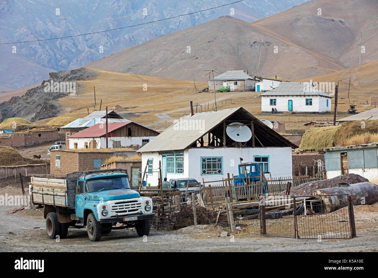 Old truck and houses in the small rural village Sary-Tash in the Alay Valley of Osh Region, Kyrgyzstan Stock Photo