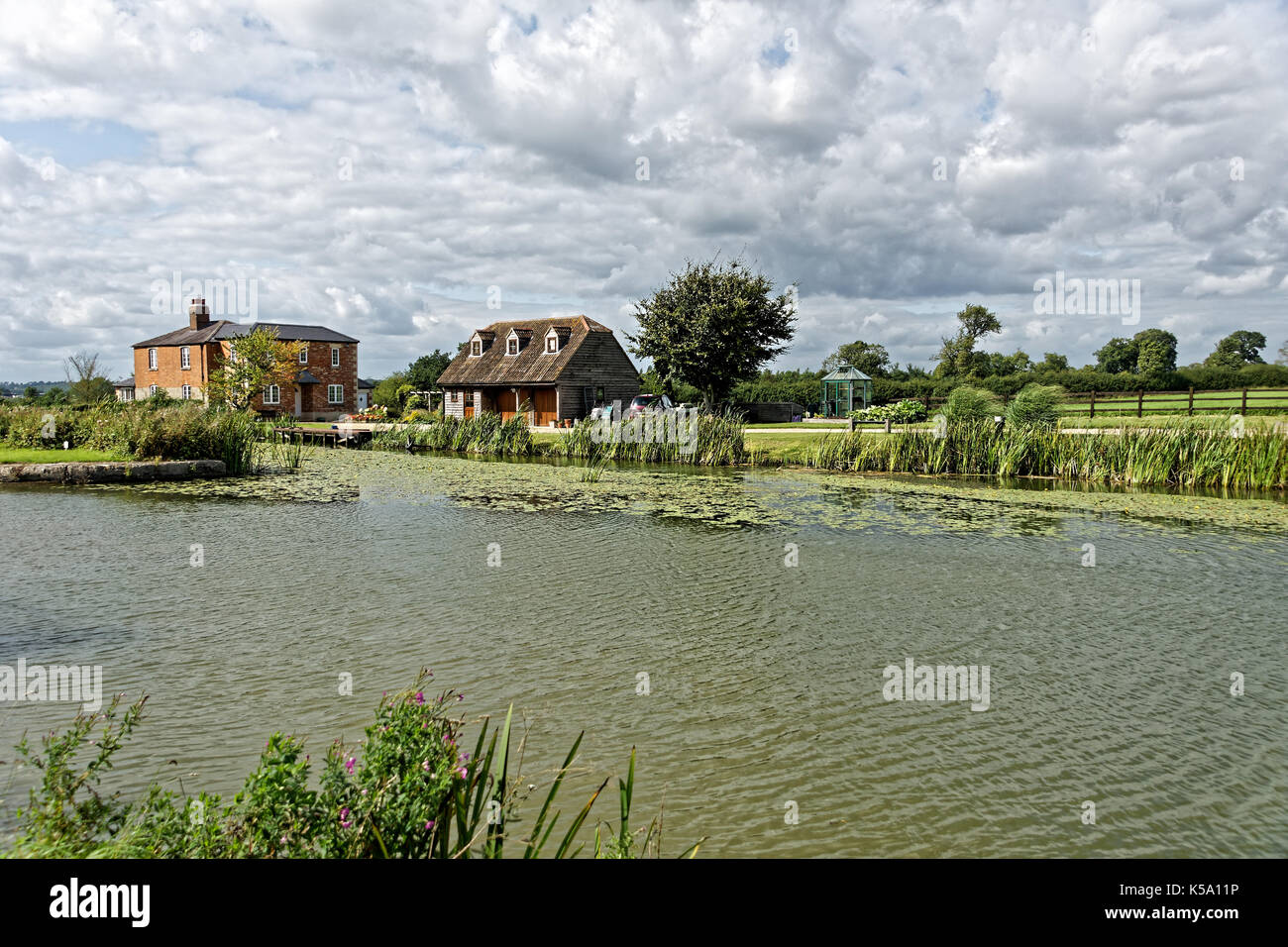 country style house on banks of canal. Stock Photo