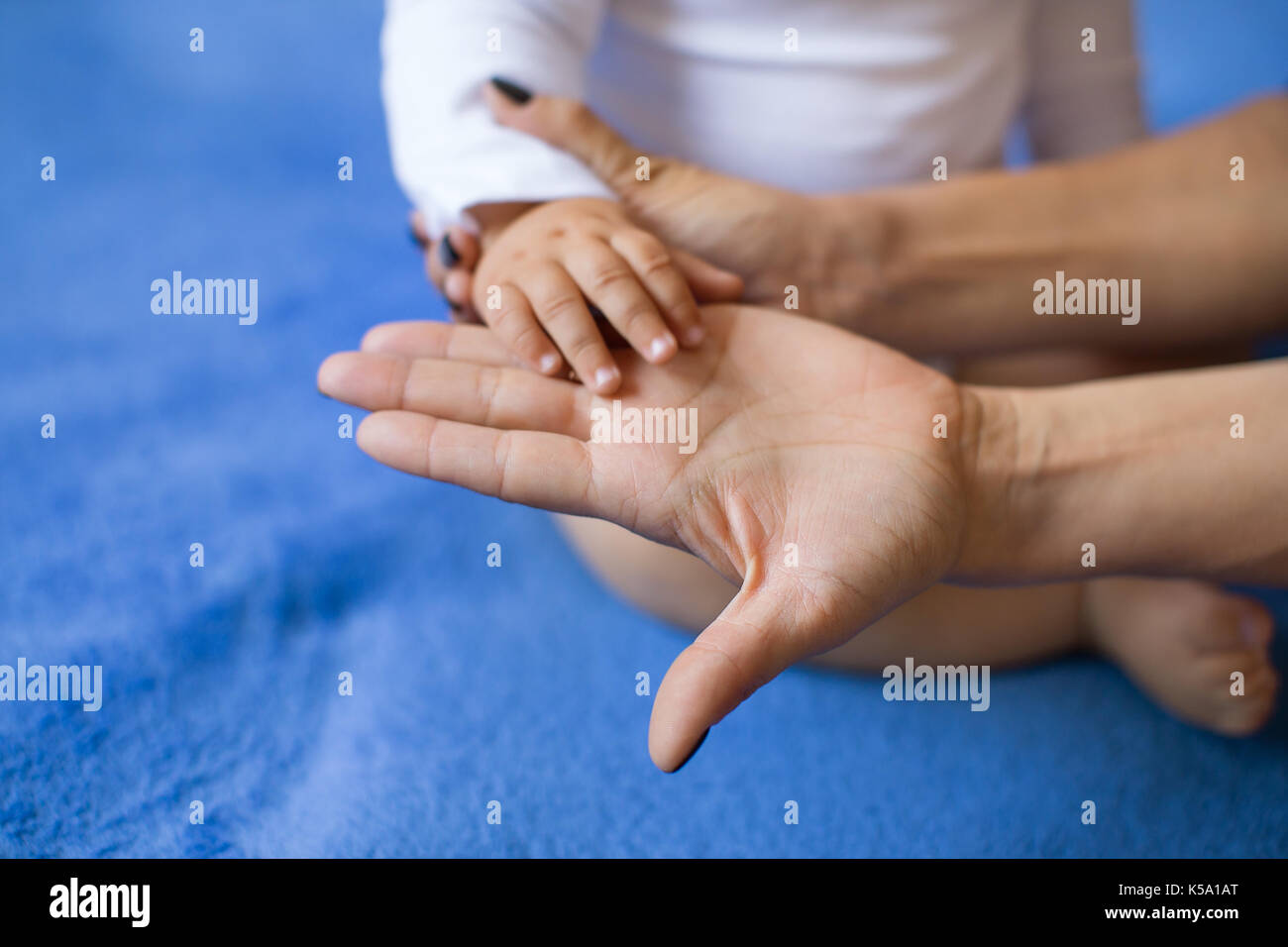 Children's hand on the palm of a woman Stock Photo