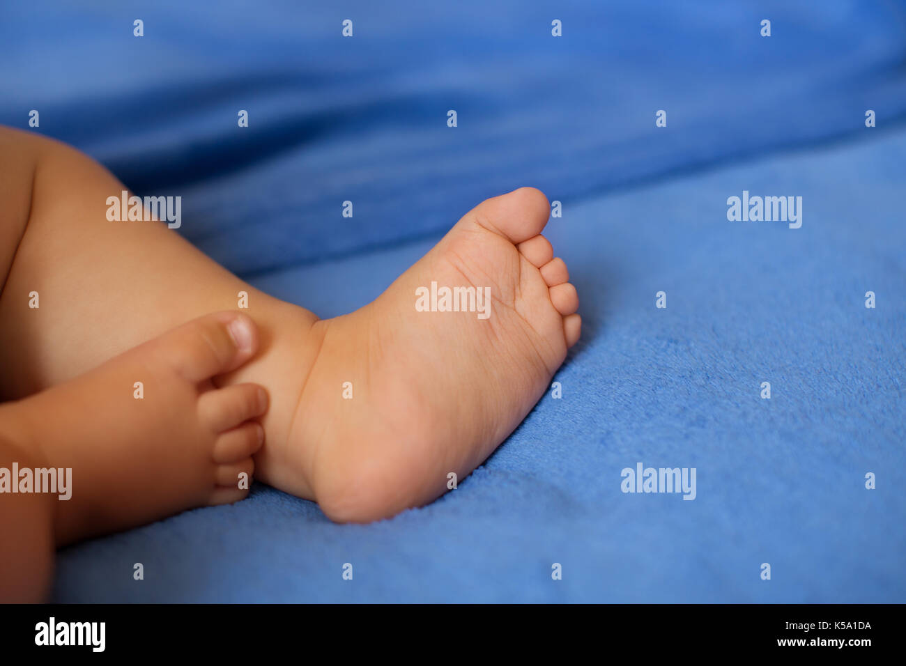 Baby legs on the bed Stock Photo