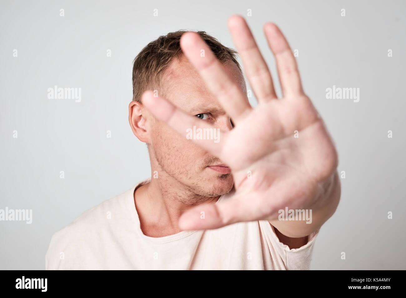 Young Caucasian man hiding his face with hand Stock Photo