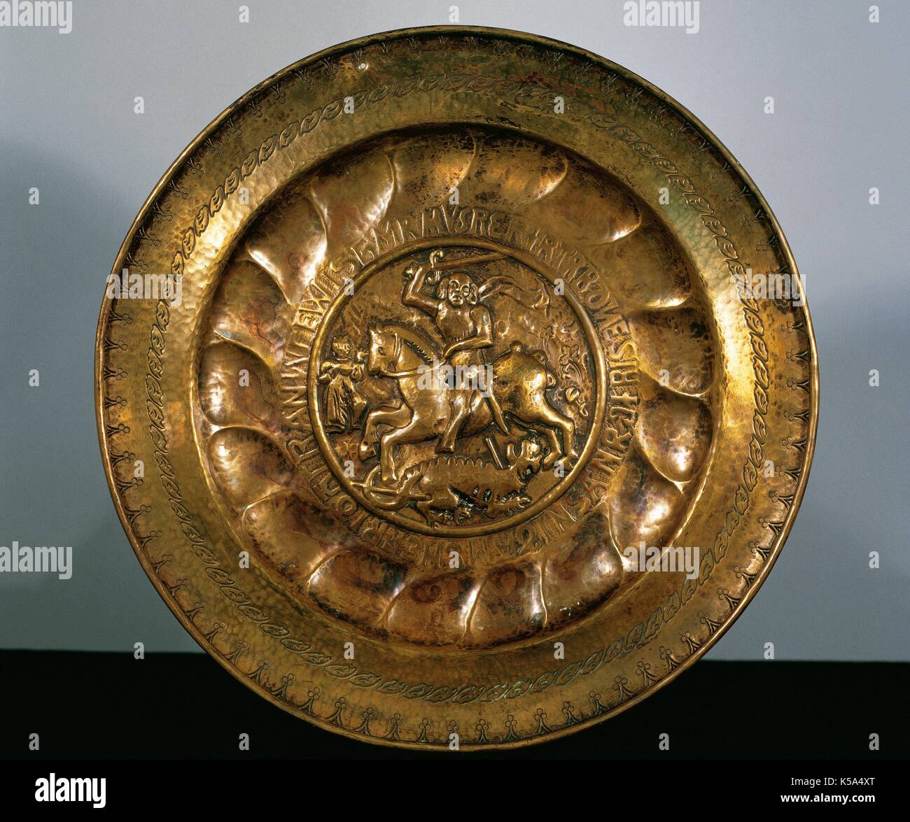 Bowl. Anonymous author. Brass. Ending of XVI Century In the middle scene of St. George (Sant Jordi / San Joge) by horse killing the dragon. Diocesan Museum of Solsona. Catalonia. Spain. Stock Photo