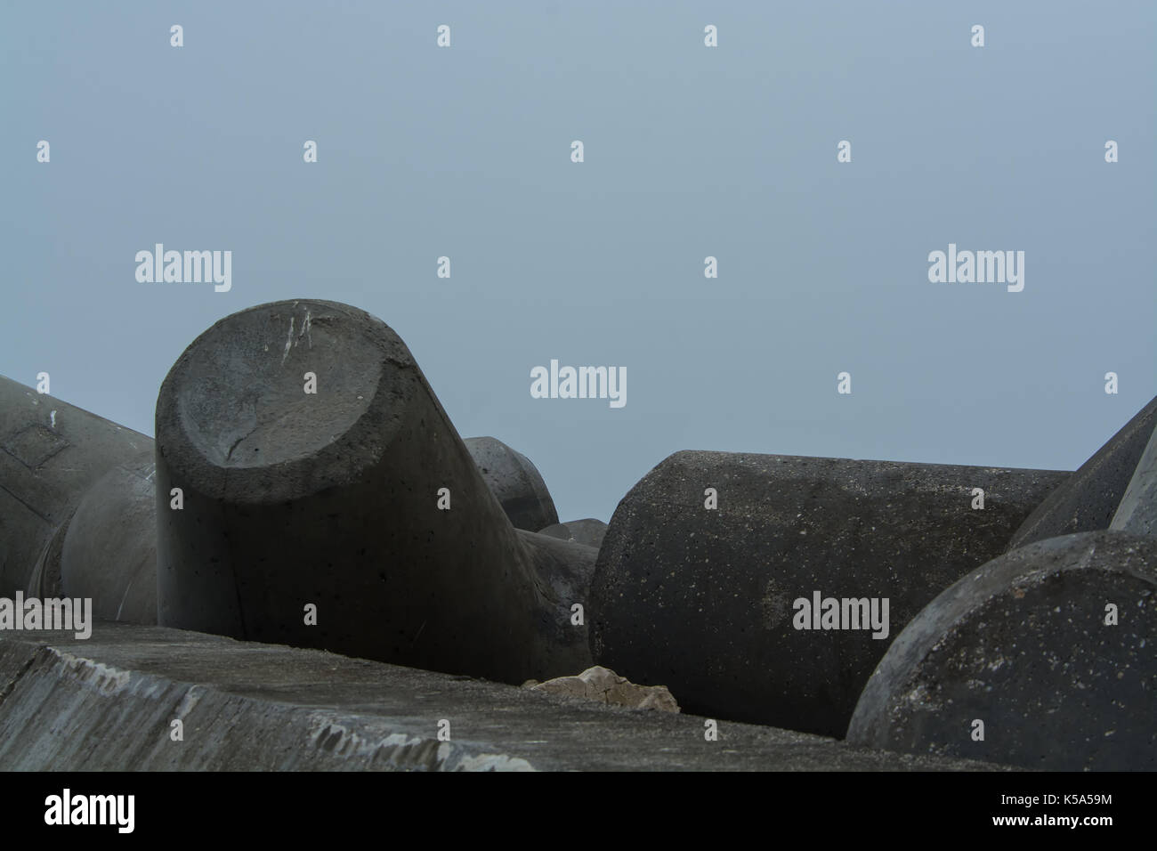 cement structure and rocks for stopping the sea in a pier in a foggy ...