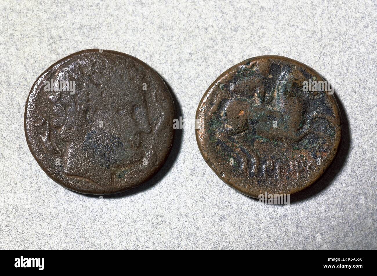 Roman Hispania. Roman coin called As. Bronze. Coined in the Mint of Iltirda (Lerida, Catalonia, Spain). Front (left), a head with dophins. Back (right), rider with palm. Museum of History, Sabadell (province of Barcelona, Catalonia, Spain). Stock Photo