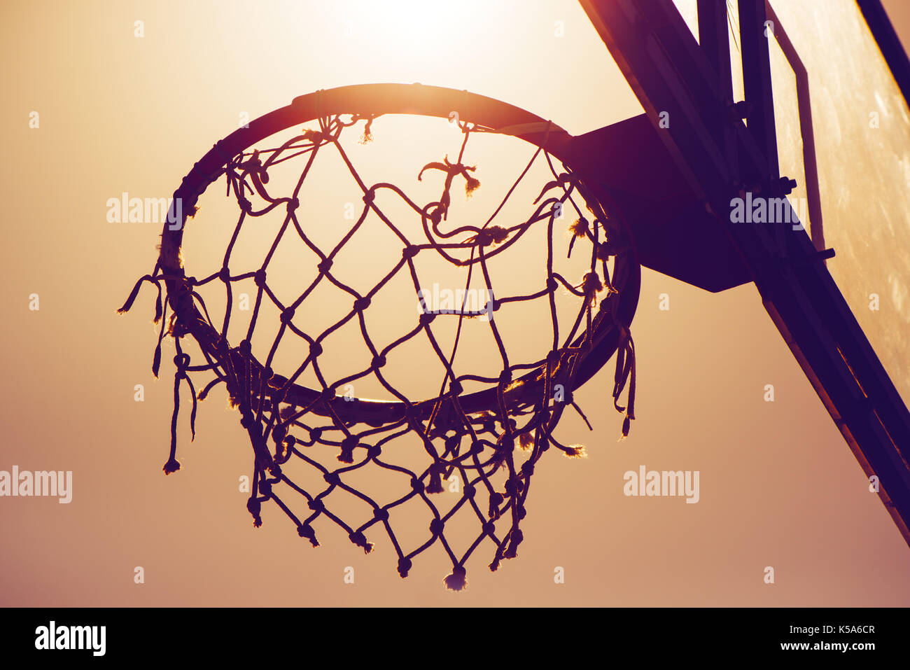 Basketball hoop on amateur outdoor basketball court for streetball, against strong summer sunlight Stock Photo