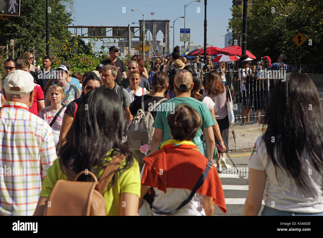 Crowds of tourists walk over Brooklyn Bridge on a sunny Labor Day holiday Stock Photo