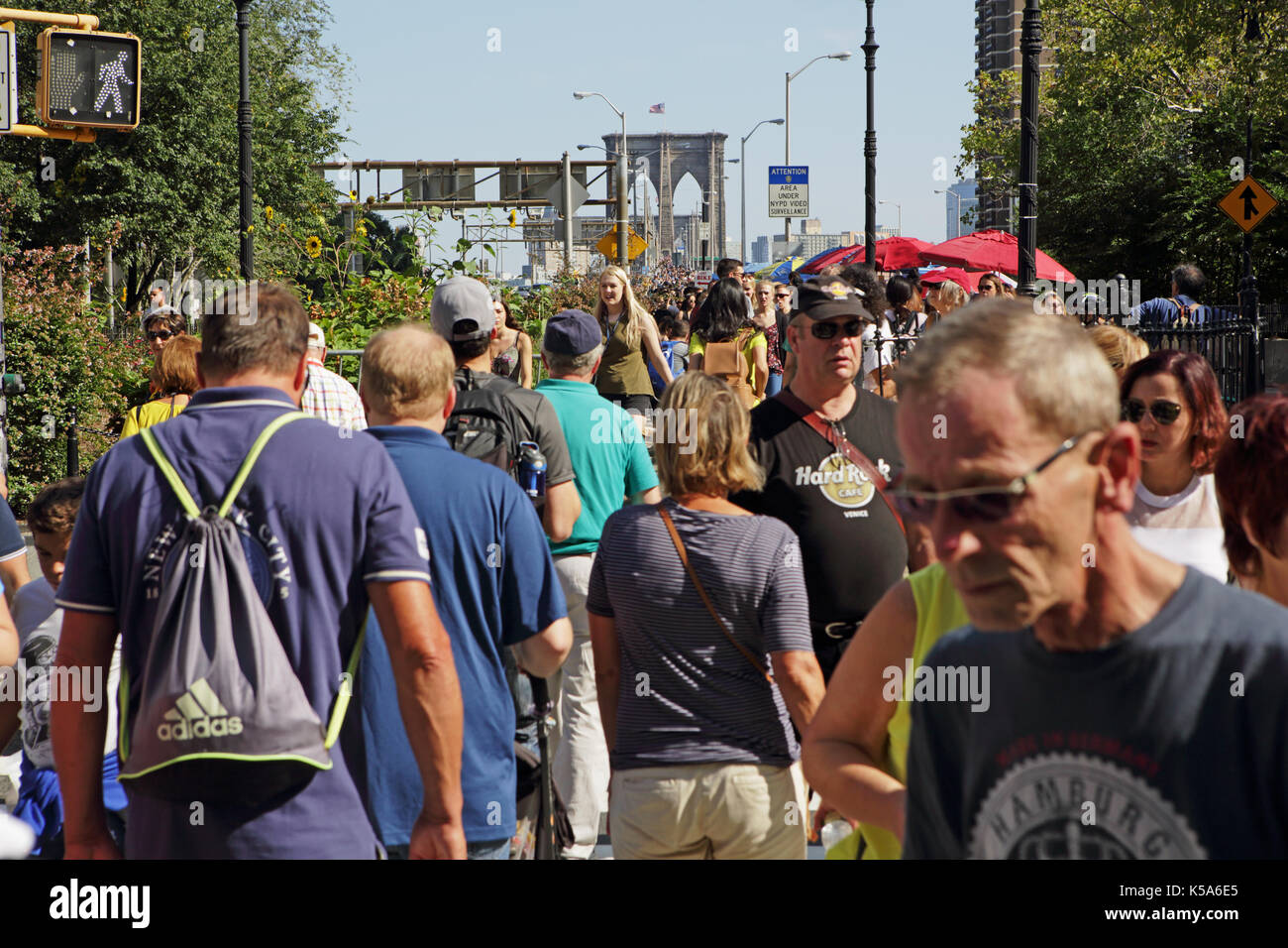 Crowds of tourists walk over Brooklyn Bridge on a sunny Labor Day holiday Stock Photo