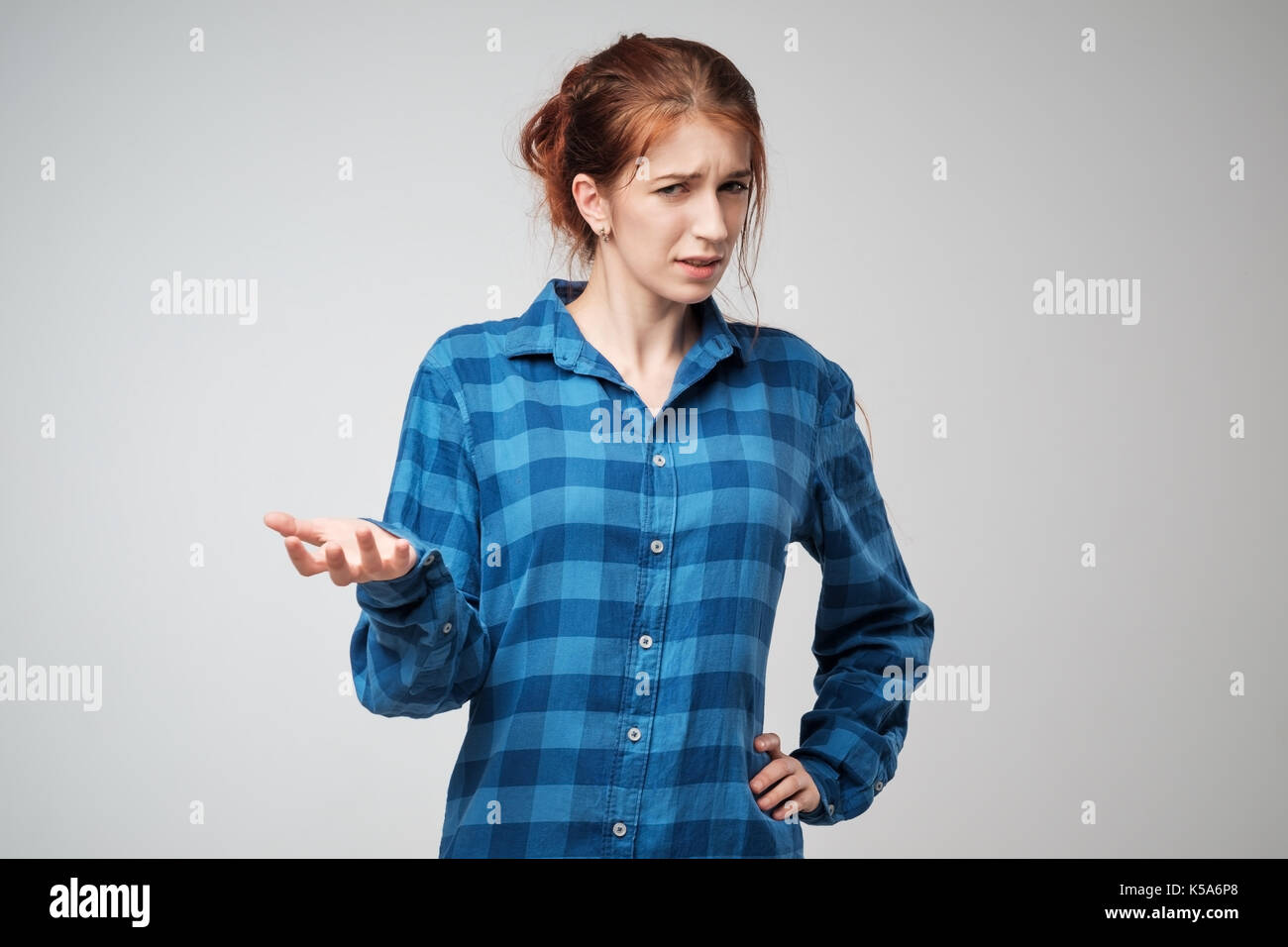 Portrait young angry woman in blue t-shirt. She is unhappy, annoyed by something. Stock Photo