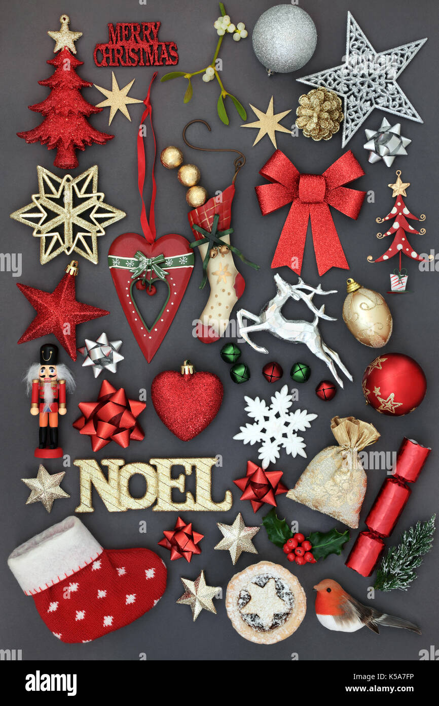 Christmas symbols with gold noel sign, new and old fashioned bauble decorations, holly, mistletoe, fir and  mince pie on grey background. Stock Photo