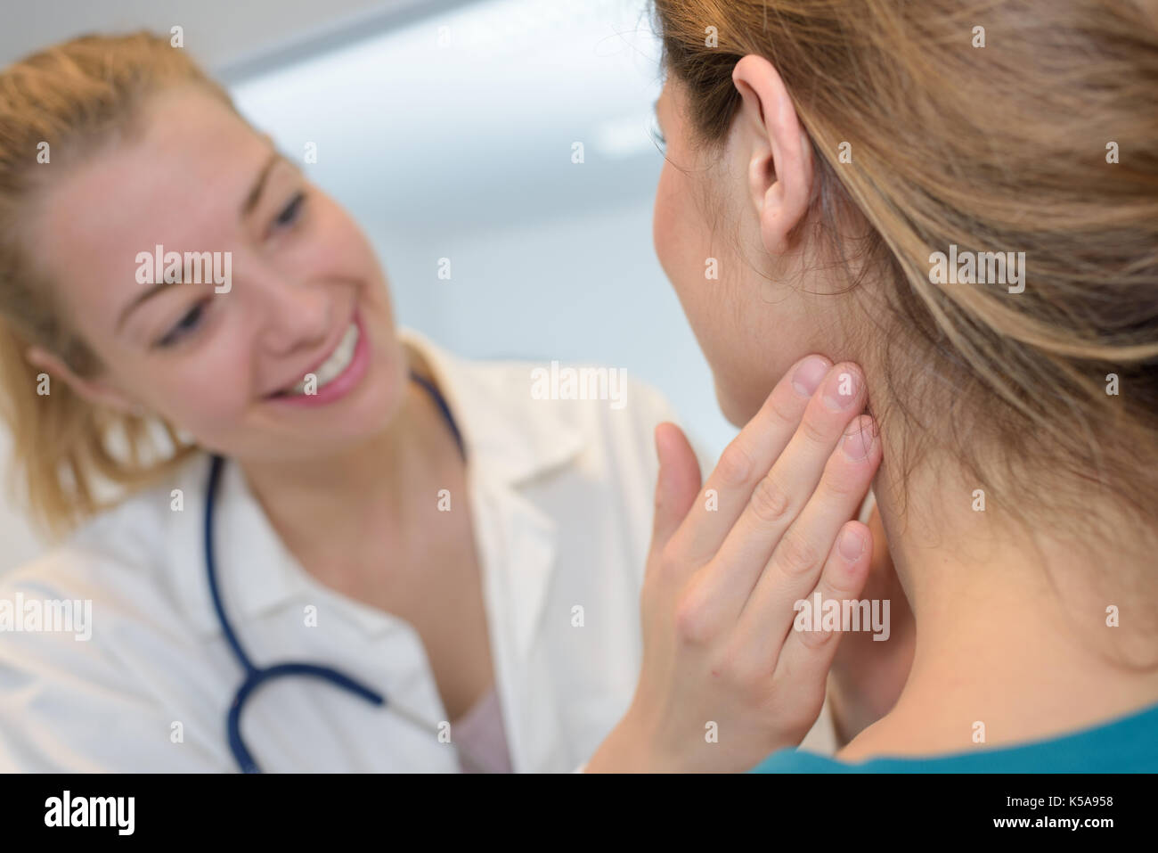 doctor checking the lymph nodes size of her patient Stock Photo