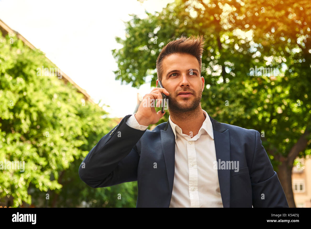 Stylish businessman in suit on sunny city street hi-res stock ...