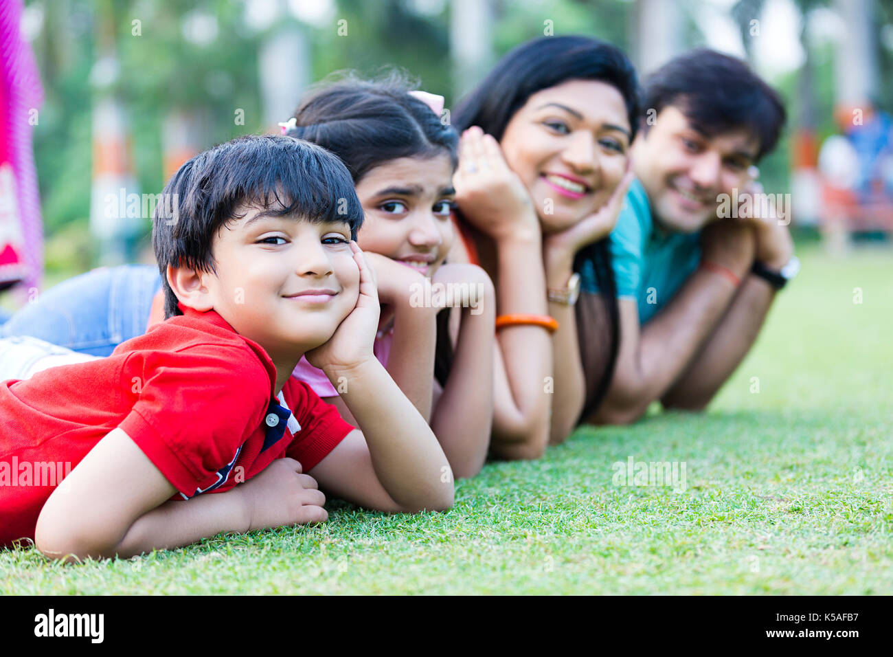 Happy Indian Family Lying Grass Relaxing Enjoying Smiling Stock Photo