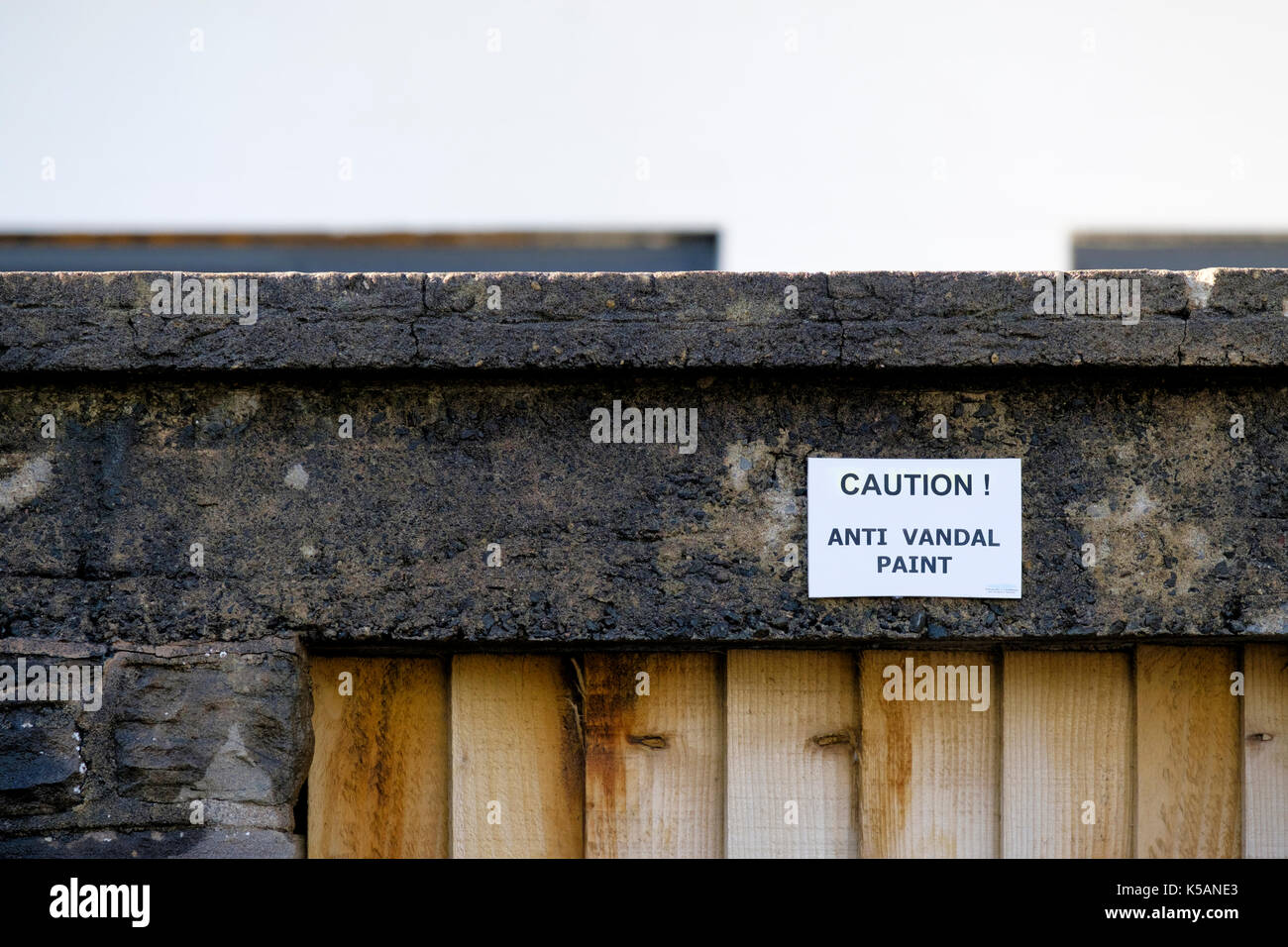 A mandatory sign placed on a house wall warning the the owner has used anti vandal paint in the vicinity Stock Photo