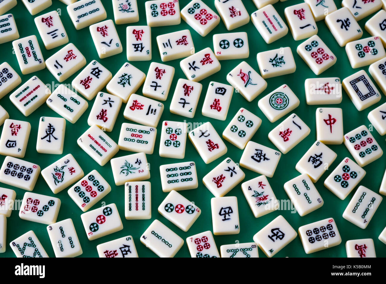 Mahjong tiles spread over green velvet canvas Stock Photo