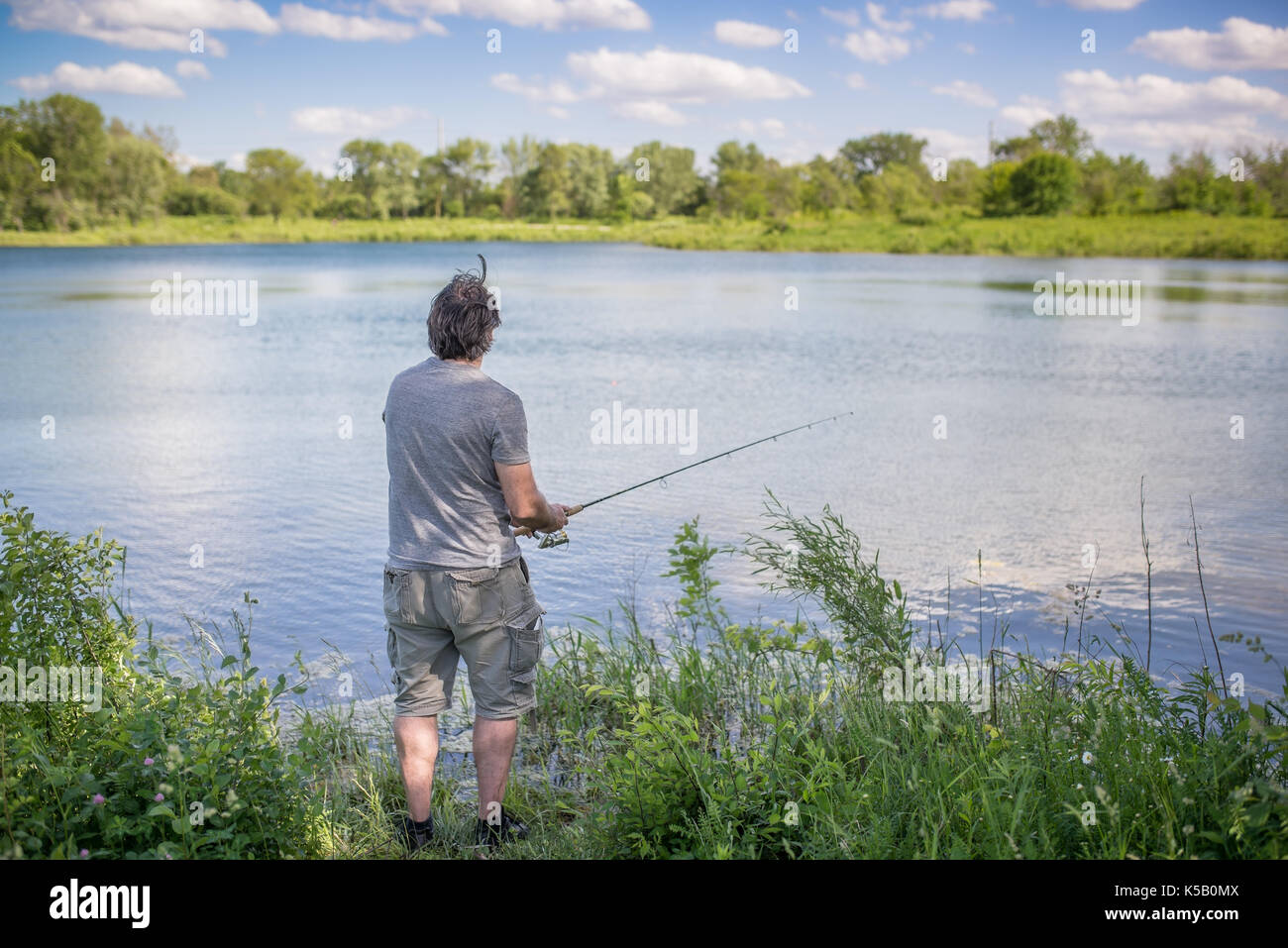 Man rod and line fishing lake water leisure hi-res stock