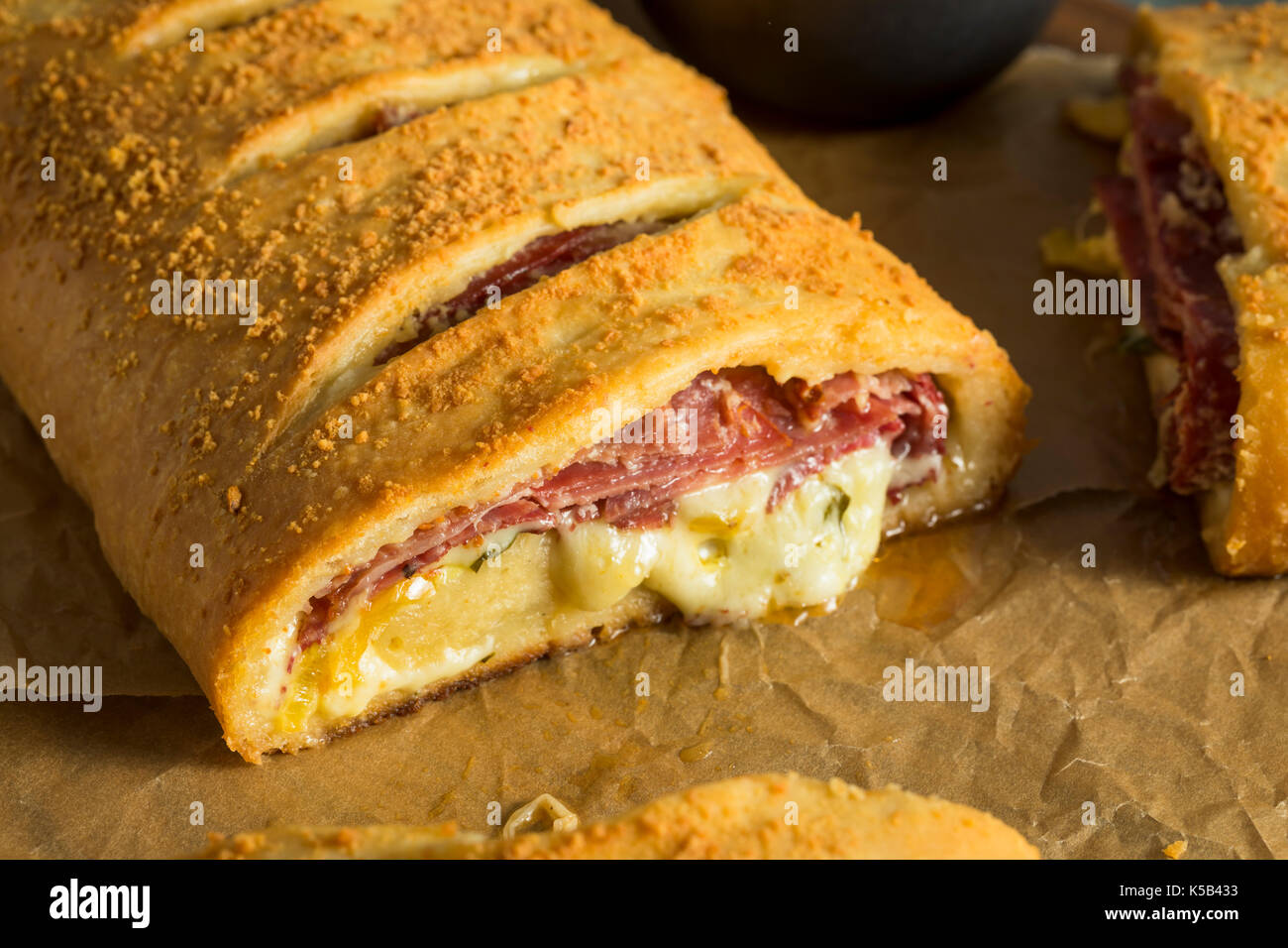 Homemade Cheesy and Meaty Italian Stromboli with Marinara Sauce Stock Photo