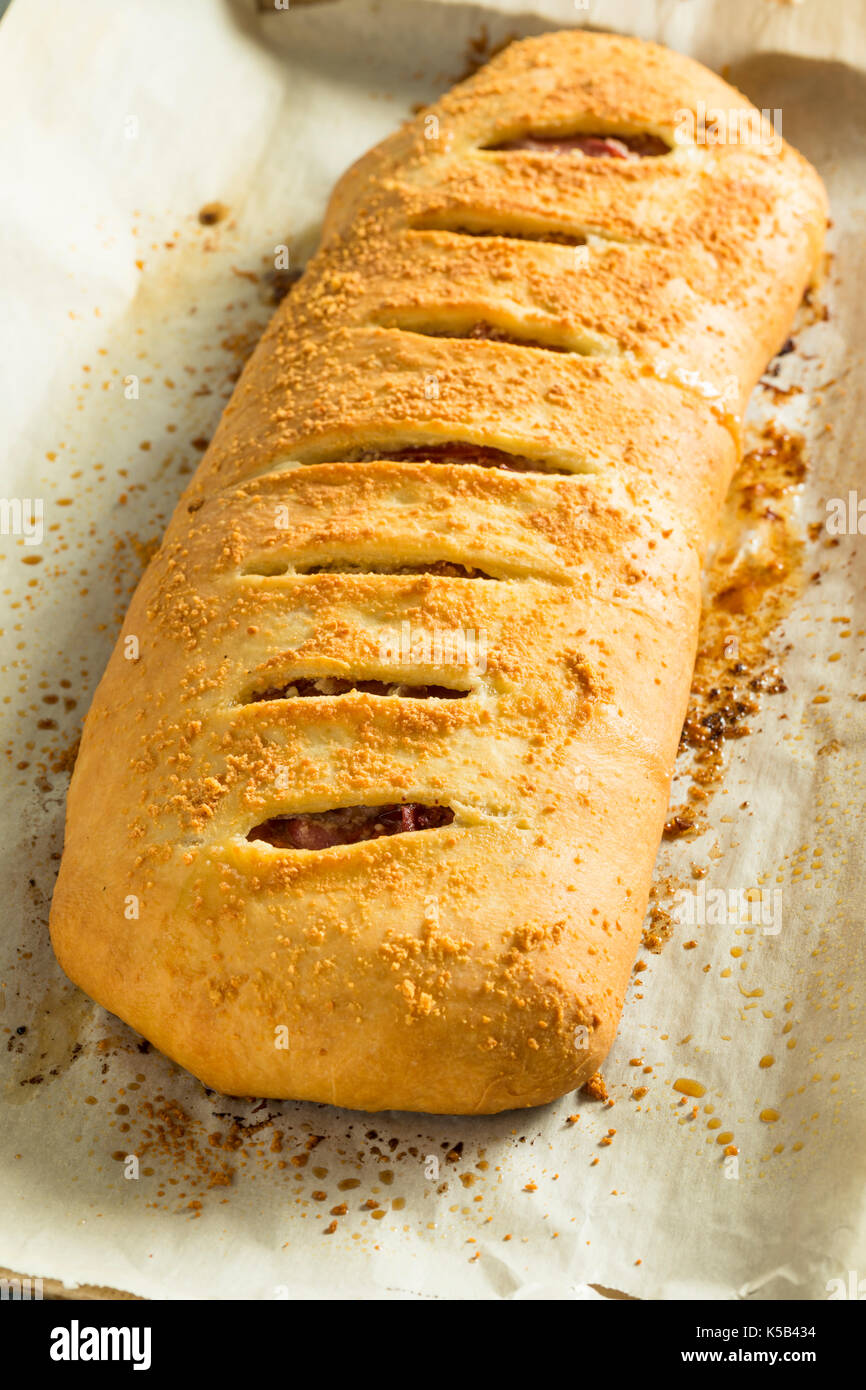 Homemade Cheesy and Meaty Italian Stromboli with Marinara Sauce Stock Photo