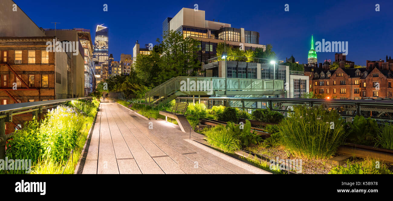 Panoramic view of the High Line promenade at twilight with city lights and illuminated skyscrapers. Chelsea, Manhattan, New York City Stock Photo