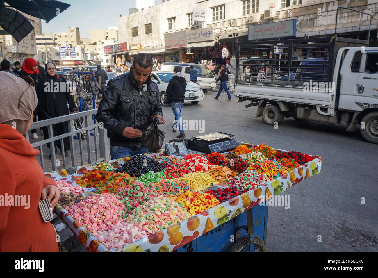Hawker selling gummies and sweet on his portable cart in downtown Amman Stock Photo
