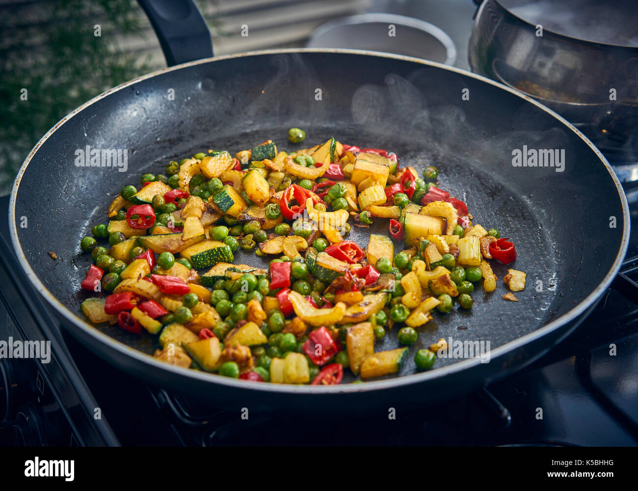 Frying colourful fresh vegetables in a frying pan Stock Photo Alamy