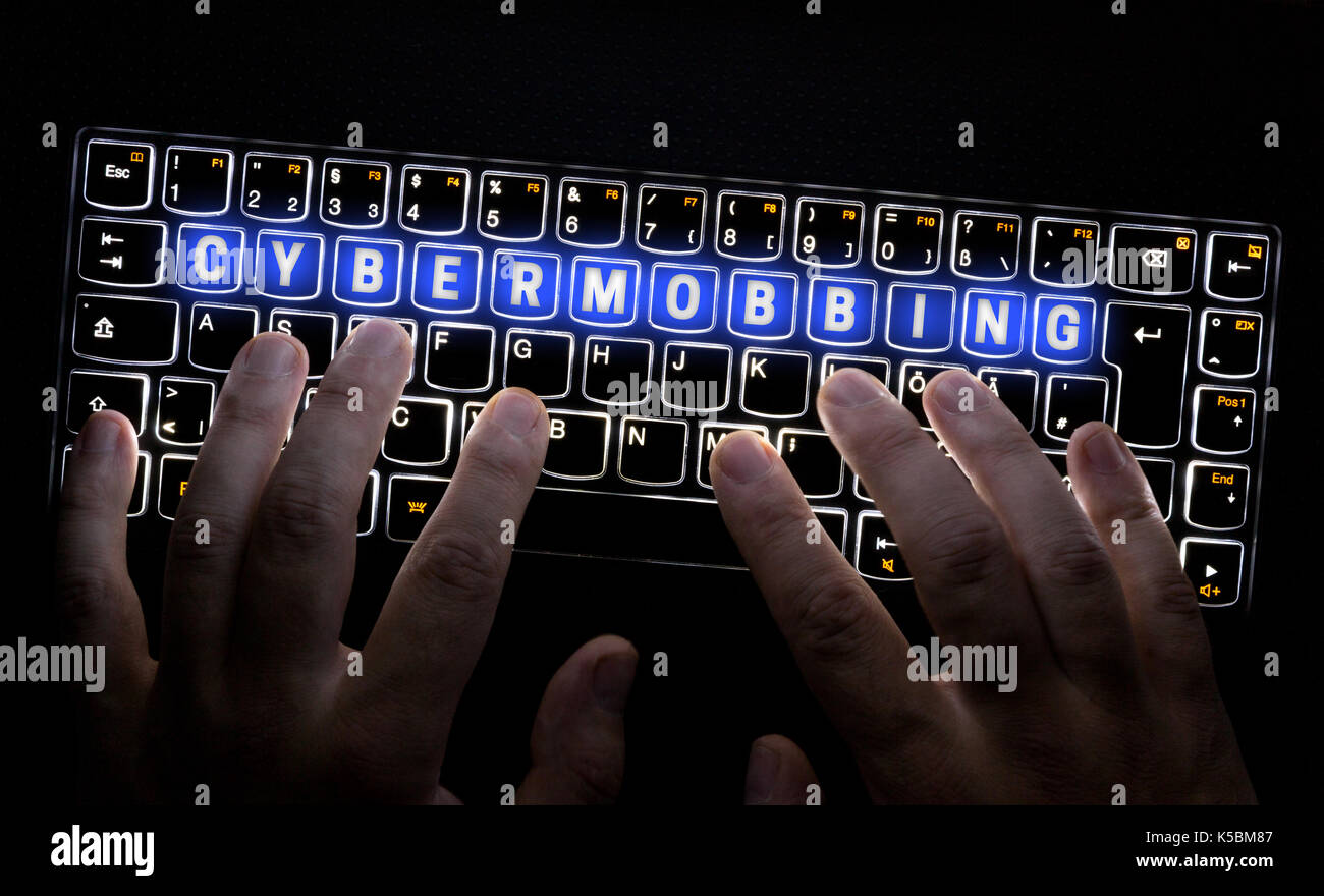 Cybermobbing keyboard is operated by hacker. Stock Photo