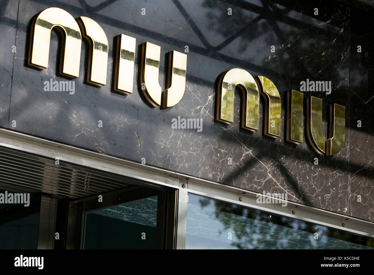 A logo sign outside of a Miu Miu clothing retail store in Barcelona, Spain on August 30, 2017. Stock Photo