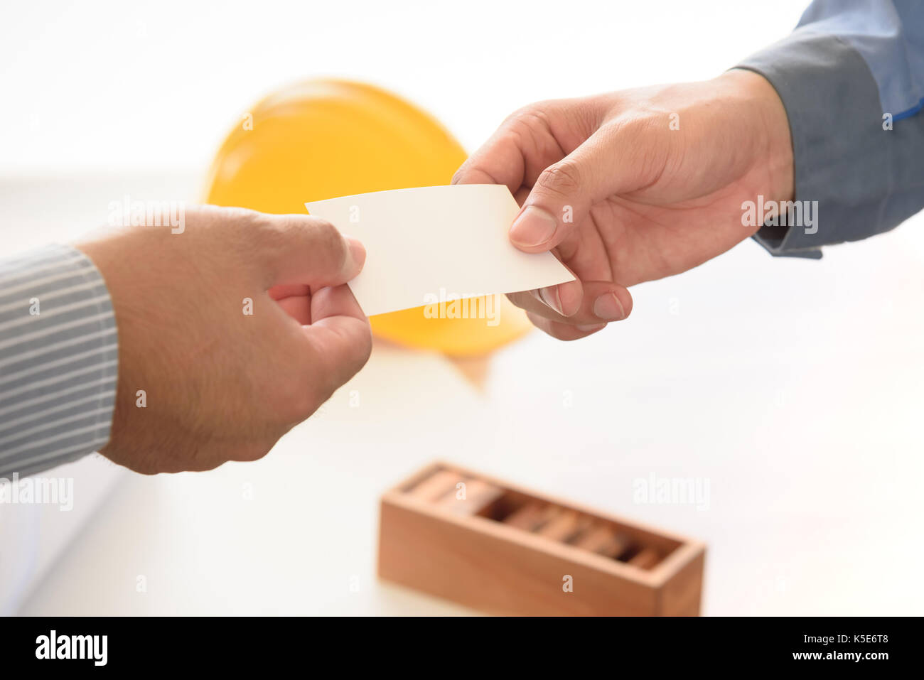 exchanging business card with engineering tools background, selective focus Stock Photo