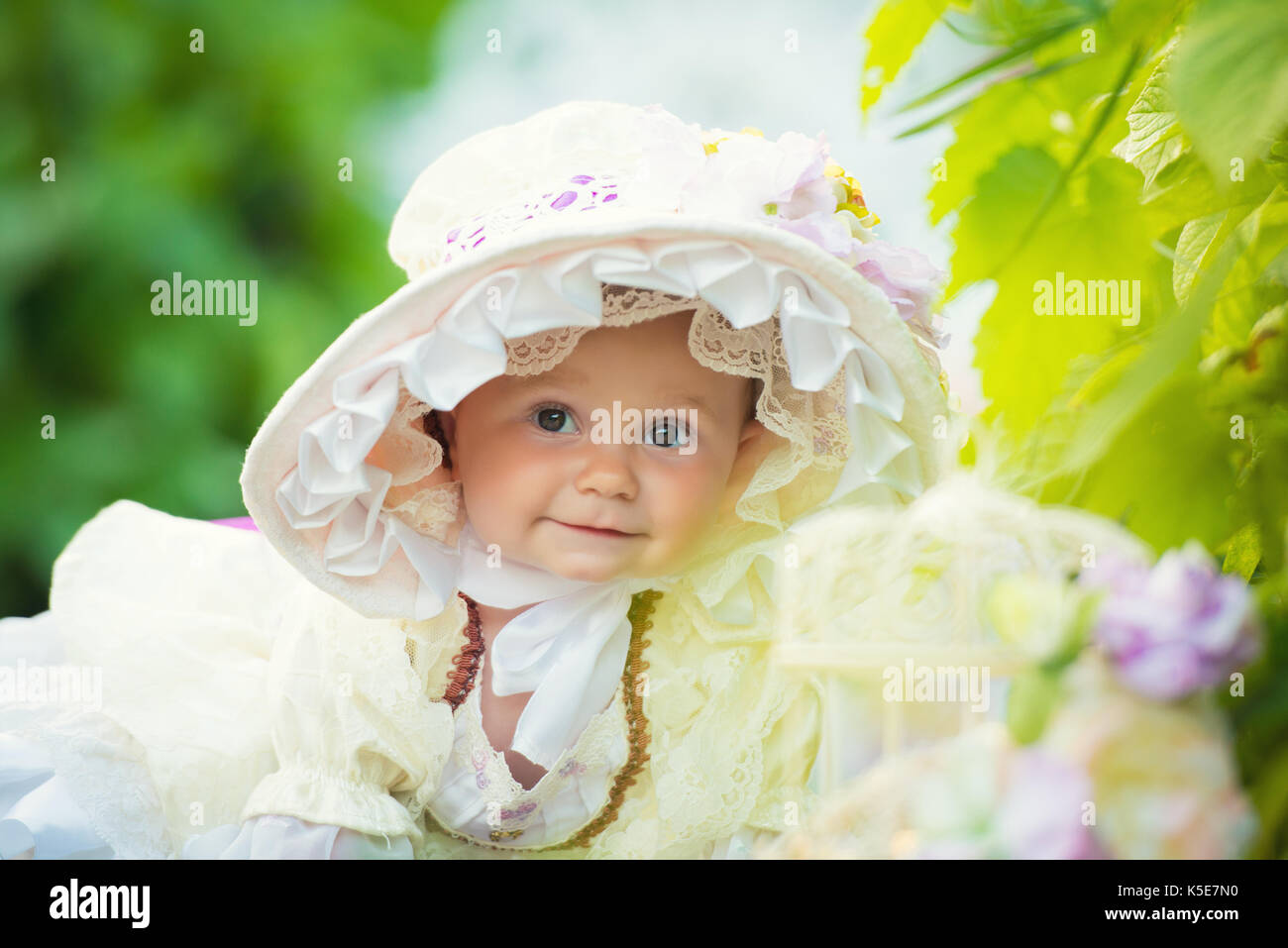 Beautiful little girl in a white dress and hat in a spring garden Stock ...