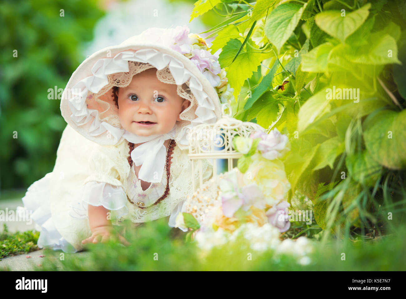 Beautiful little girl in a white dress and hat in a spring garden Stock ...
