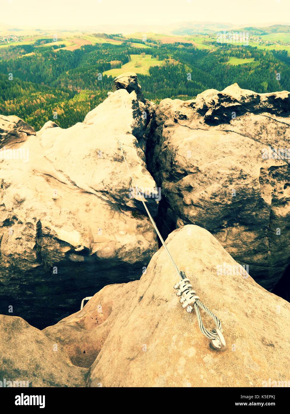 Iron twisted rope stretched between rocks in climbers patch via ferrata ...