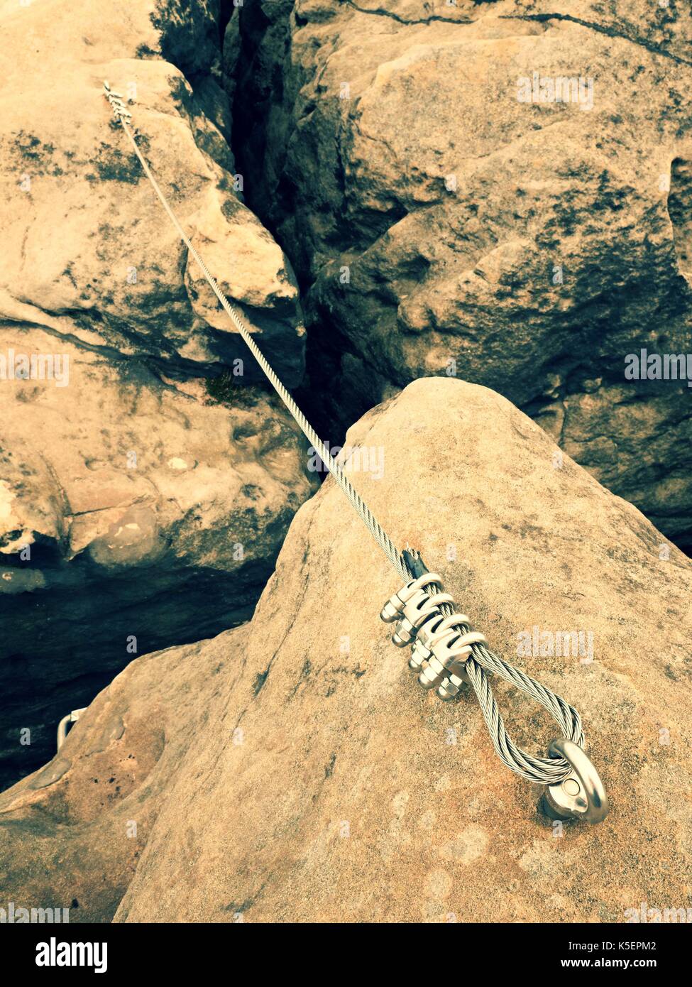 Iron twisted rope stretched between rocks in climbers patch via ferrata ...
