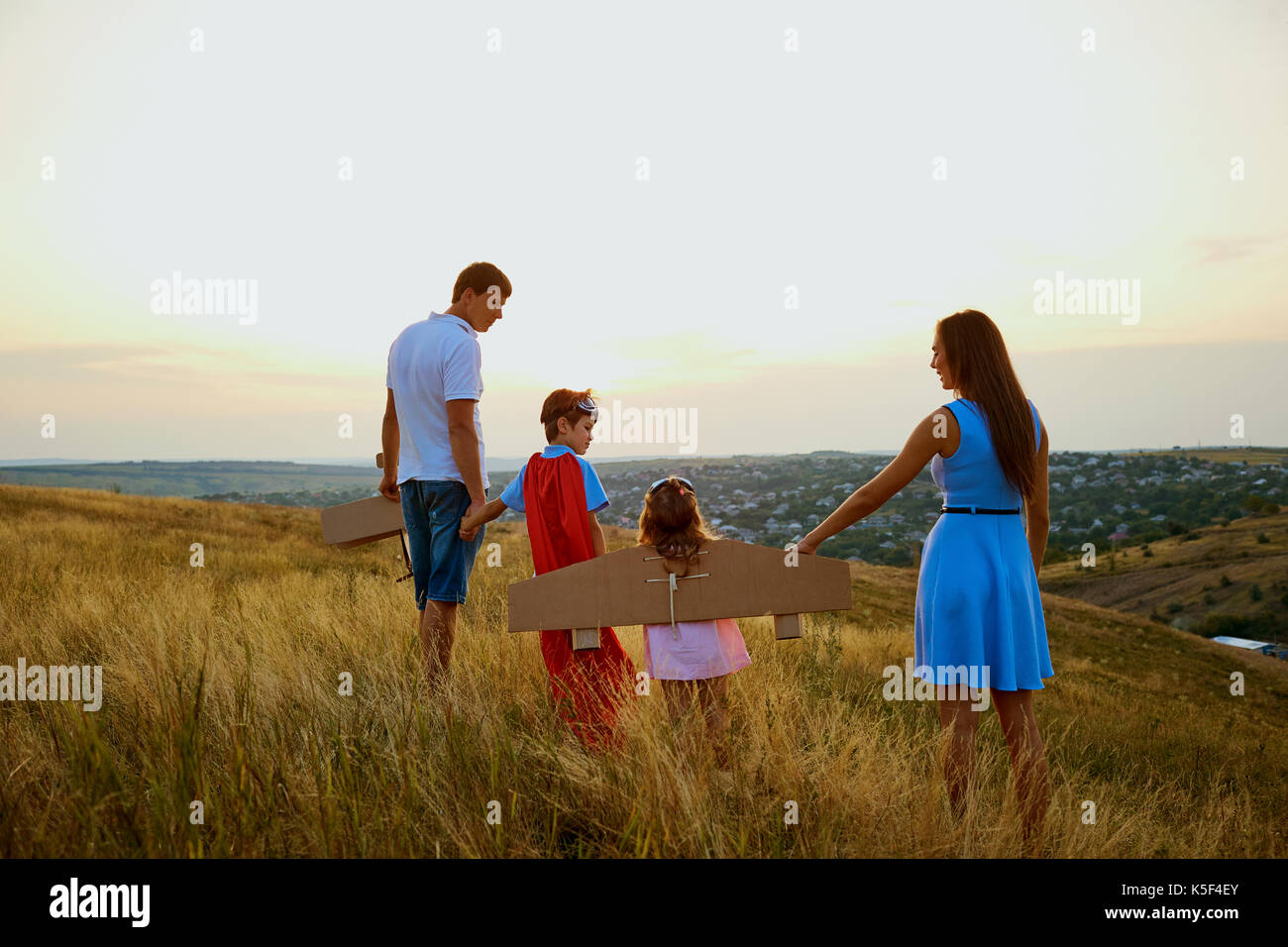 Family in the evening at sunset field in nature. Stock Photo