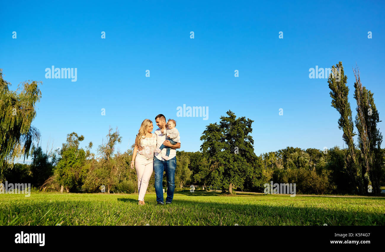 Happy young family in the park on a sunny day. Stock Photo