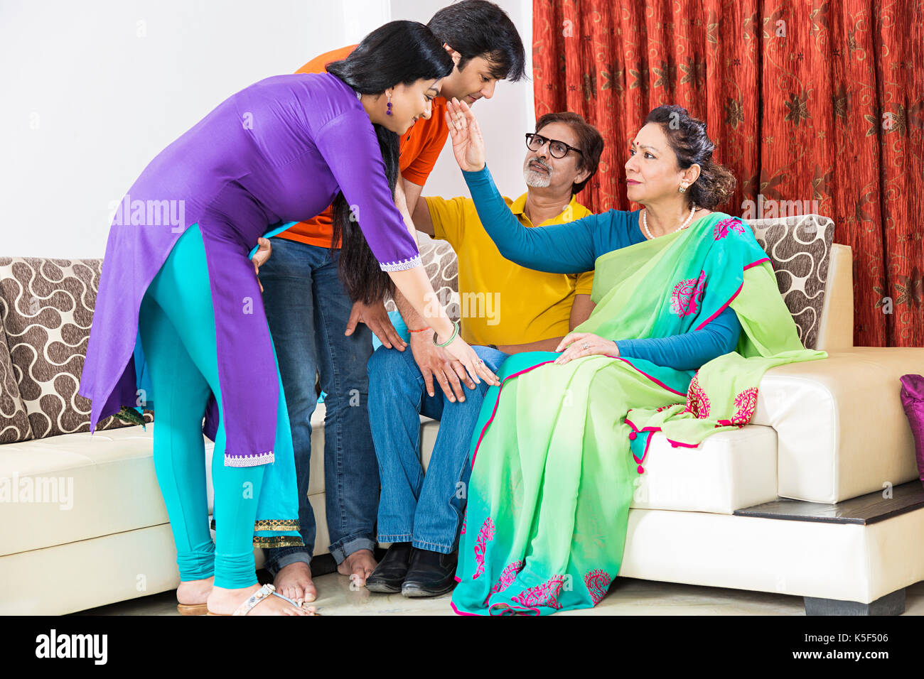 Indian Parents son With Daughter-In-Law Touching Feet Blessing Parenting Stock Photo
