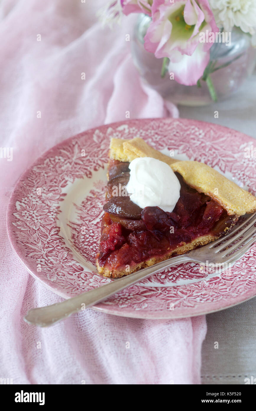 Galette with plums and cream. Rustic style, selective focus. Stock Photo