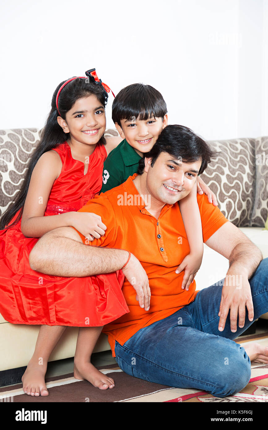 Father and Kids Son And Daughter Sitting On Sofa Living Room Stock Photo