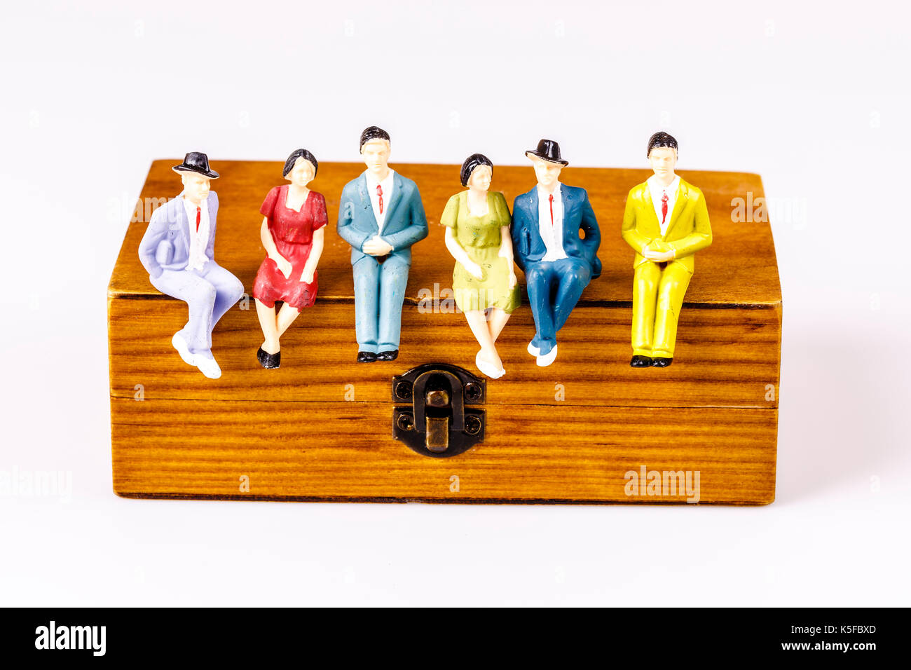 toy models of people sitting on the wooden box on white Stock Photo Alamy