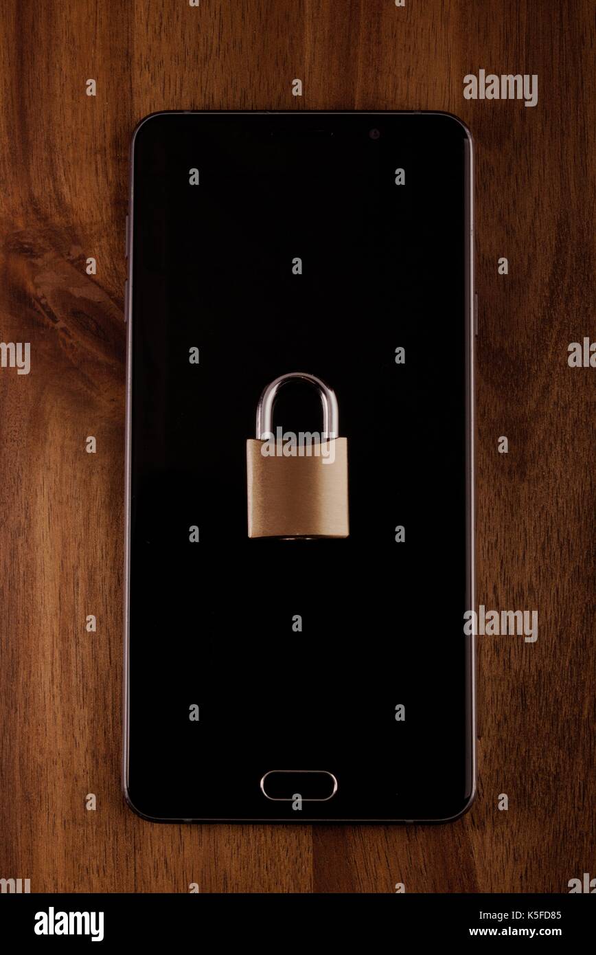 cellphone data security - lock and phone on wood Stock Photo