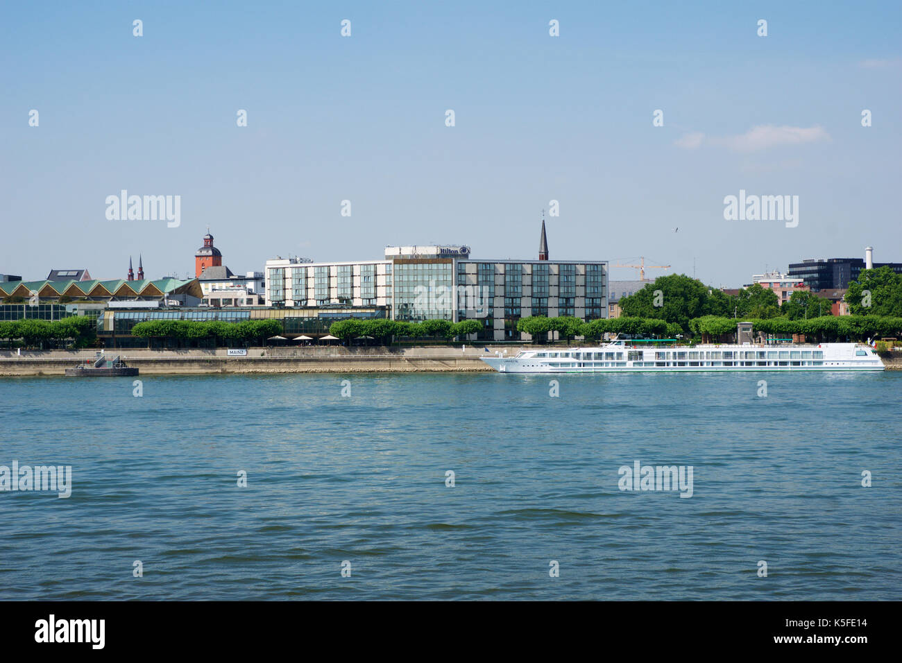 MAINZ, GERMANY - JUL 09th, 2017: Luxury Hilton Hotel next to the Rhine german Rhein. Outside view from the opposite river side. Hilton Hotels Resorts is an international chain of full service hotels and resorts of Hilton Worldwide. Stock Photo