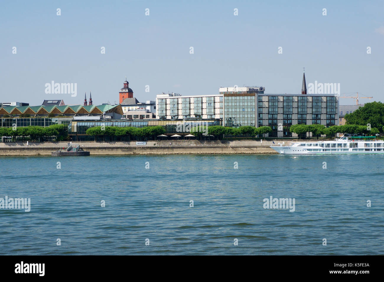 MAINZ, GERMANY - JUL 09th, 2017: Luxury Hilton Hotel next to the Rhine german Rhein. Outside view from the opposite river side. Hilton Hotels Resorts is an international chain of full service hotels and resorts of Hilton Worldwide. Stock Photo