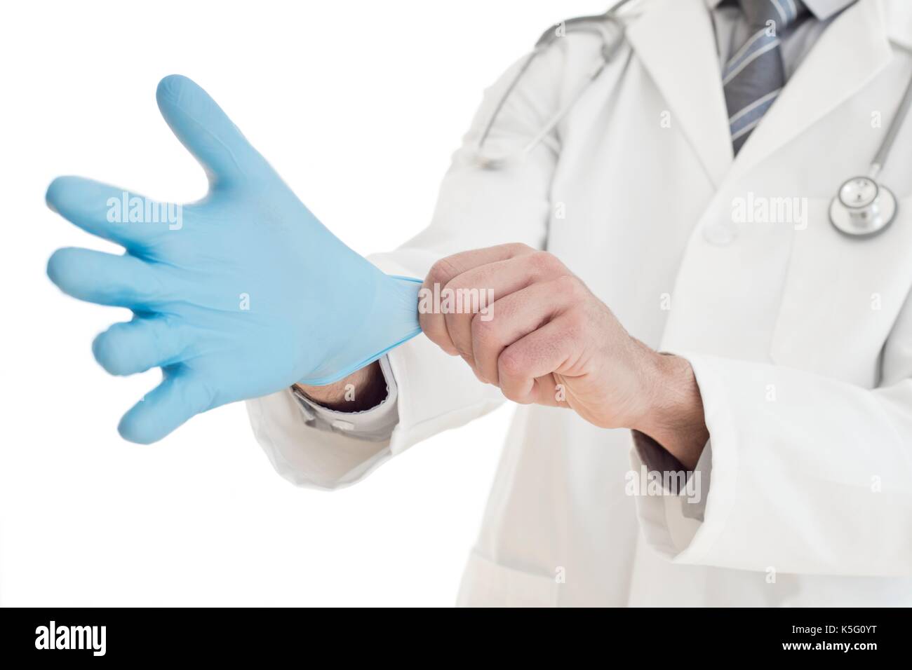 Male doctor putting on blue latex glove, close up. Stock Photo