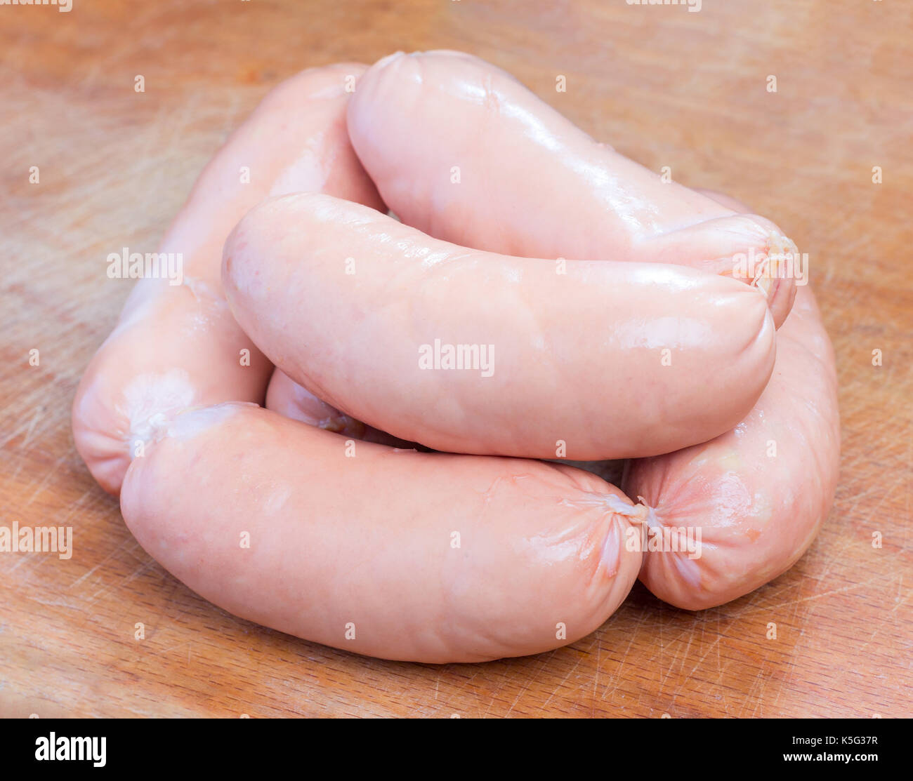 a bunch of pink meat sausages on a cutting board closeup Stock Photo